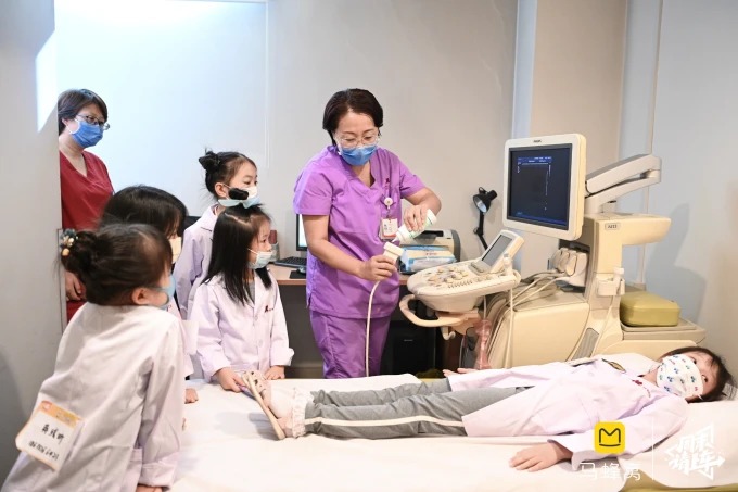 模擬患者にプローブを当てる子どもたち