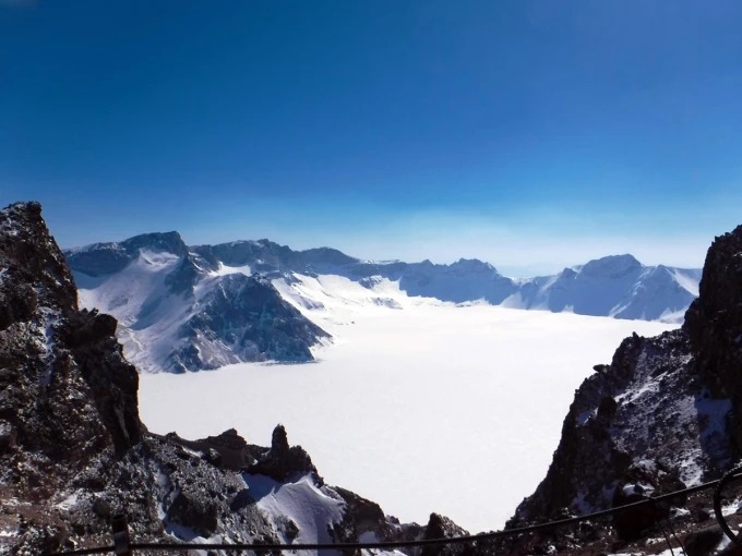 Verschneiter Tianchi zwischen Changbaishans Gipfeln