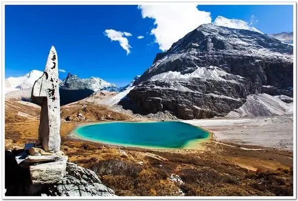 Highland lake below snow peaks in Yading