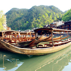 Boat passing old riverside buildings on the Tuo River