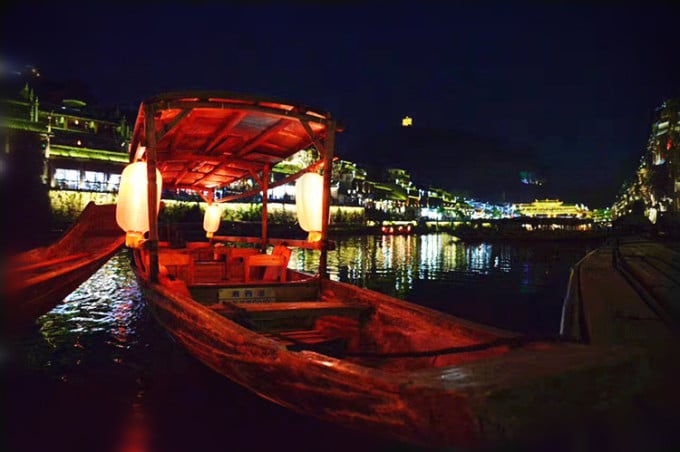 Fenghuang old town illuminated at night along the river