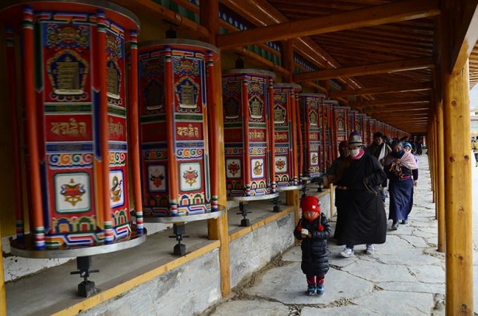 Long row of prayer wheels at Labrang Monastery