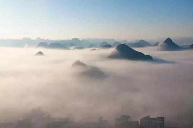Brume matinale sur les champs de colza et les pics karstiques à Jinji