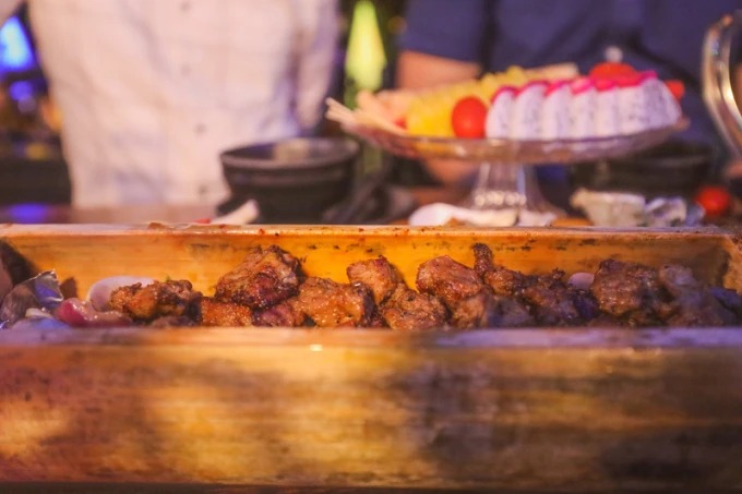 Comida a la parrilla servida en un bar en una azotea de Haikou