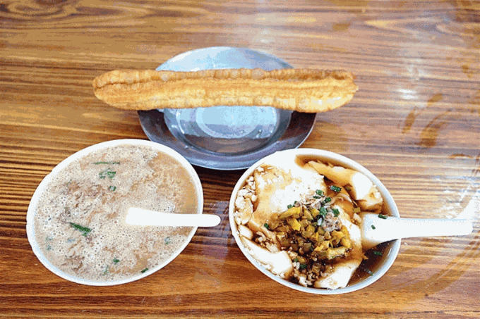 Eine Schale salzige Sojamilch mit Frühlingszwiebeln und frittiertem Teig