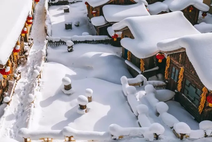 Árboles y tejados cubiertos de nieve en un pueblo invernal