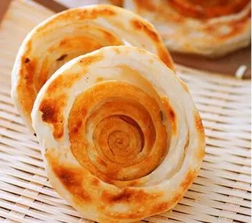Ein goldenes, spiralig geformtes Youxuan-Gebäck, ein Snack aus Jinan