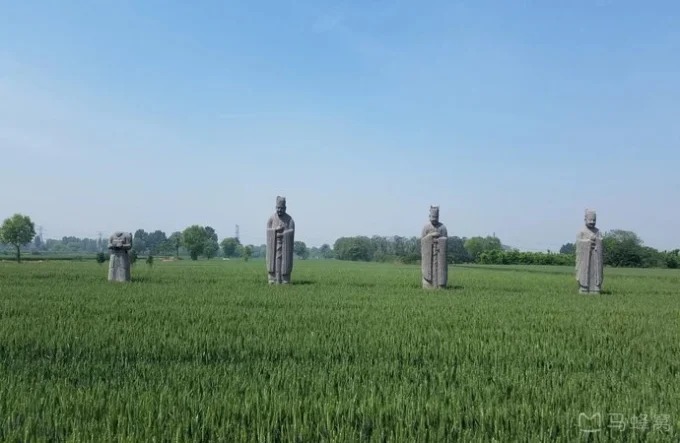 Stone guardian figure among fields at Yongyu Mausoleum