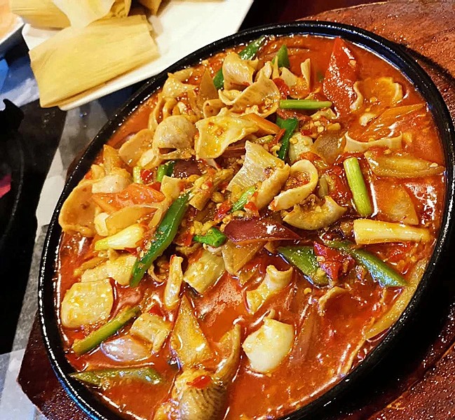 Lachs- und Hotpot-Gerichte in einem Restaurant in Lijiang