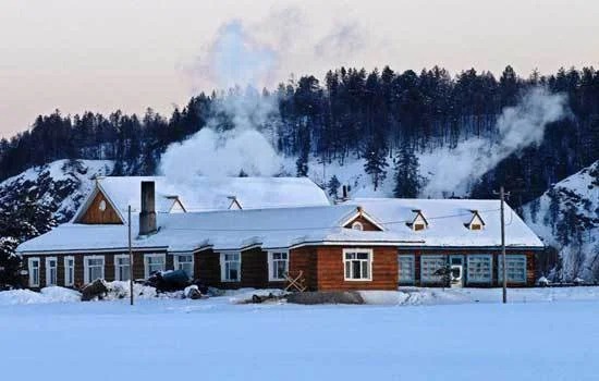 Casas de toras cobertas de neve na Vila Beiji