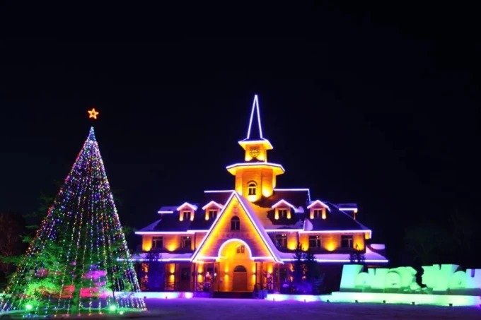 Beleuchtete Gebäude des Weihnachtsdorfs bei Nacht