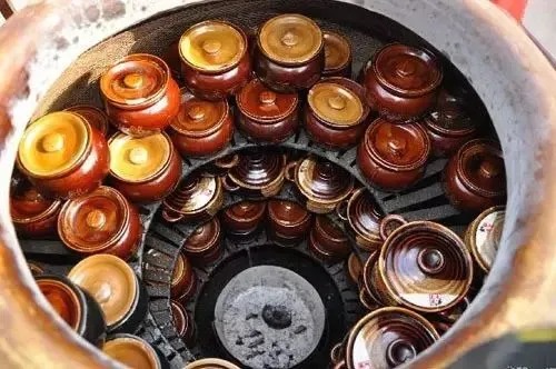 大きな陶器の壺の中に積まれた小さなスープ壺