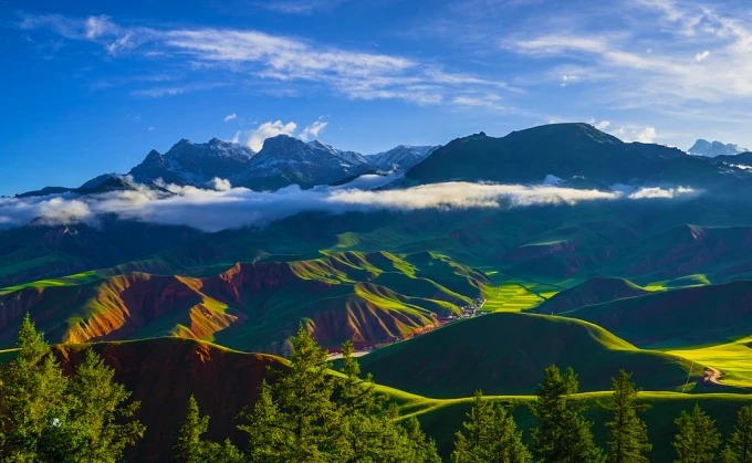 Grasland, Wald und Bergkämme im Qilian-Gebirge im Sommer