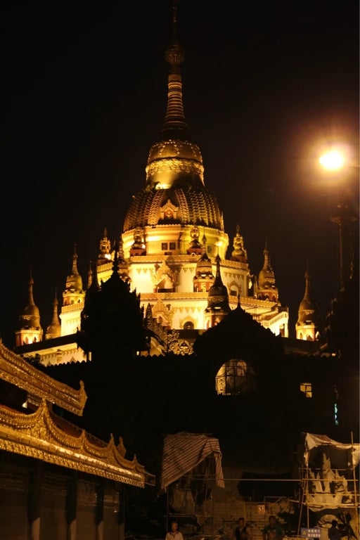 Eine reich verzierte goldene Pagode, nachts angestrahlt