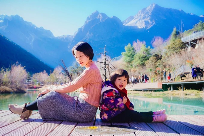Eine Frau und ein Kind an einem Bergsee bei Lijiang