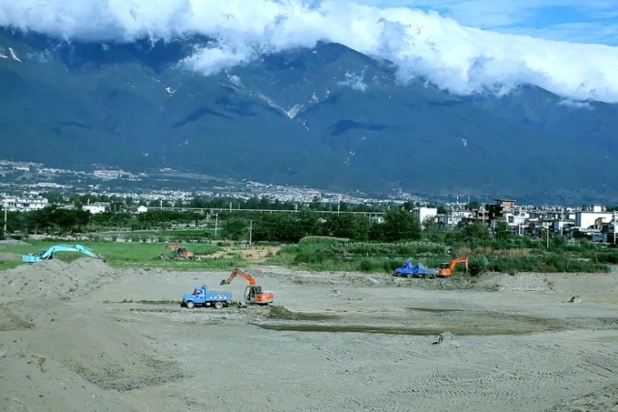 Landarbeiter heben einen renaturierten Teich auf der Chaimiduo Farm bei Shuanglang aus