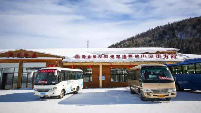 Reisebusse vor einer touristischen Umsteigestation in Snow Town