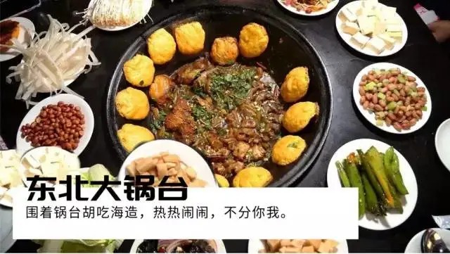 Olla grande de hierro rodeada de platos pequeños y panecillos dorados