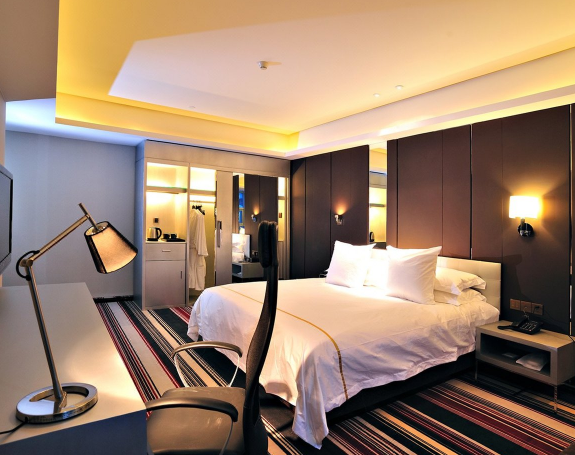 Grand lit dans une chambre de l'hôtel Bayinhe