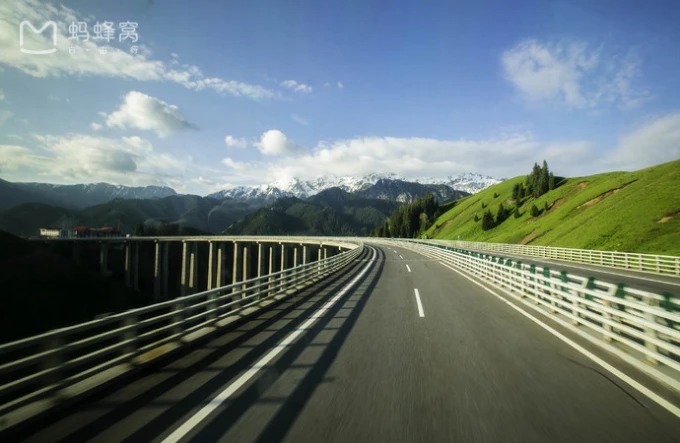 Straße, die sich durch das bewaldete Guozigou-Tal schlängelt