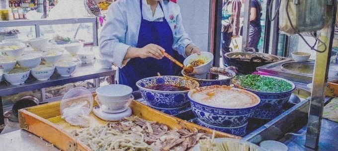 Beef noodles being prepared at a food counter in Xining