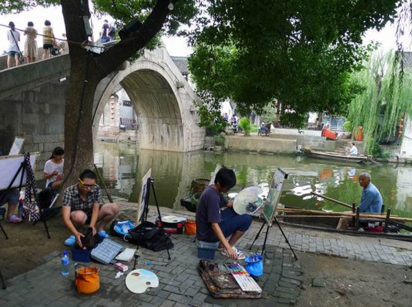 Des peintres au bord d’un canal et d’un pont de pierre à Xitang
