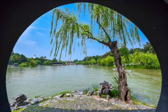 Weide und Seewasser im Rahmen einer runden Pavillonöffnung