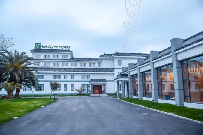 Weiße Hotelgebäude um die Zufahrt zur Hofanlage