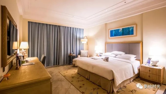 Dormitorio de hotel de tonos cálidos con escritorio